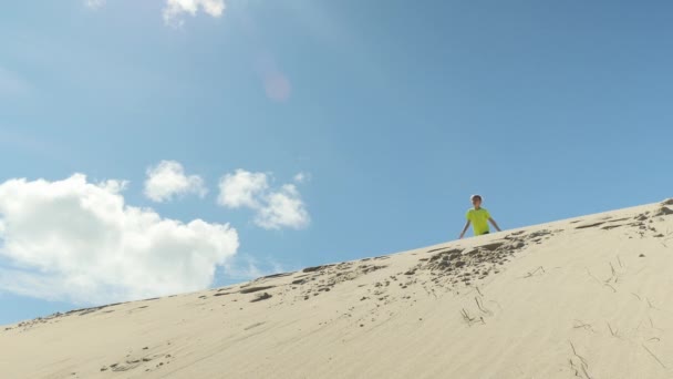 Carino ragazzo saltando giù per le dune — Video Stock