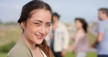 Arka plan arkadaş grubu gülümseyen genç koyu saçlı kadın