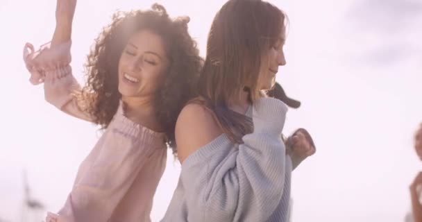 Twee aantrekkelijke jonge vrouw dansen in felle zon — Stockvideo