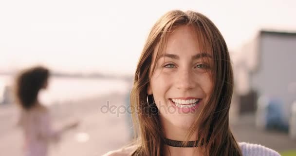Jonge bruine donkerharige vrouw lachen met vrienden op de achtergrond — Stockvideo