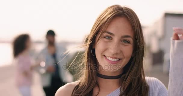 Young brown haired woman smiling with friends in the background — Stock Video