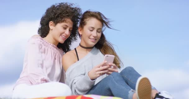 Beautiful multiethnic girlfriends outside typing on smartphone — Stock Video