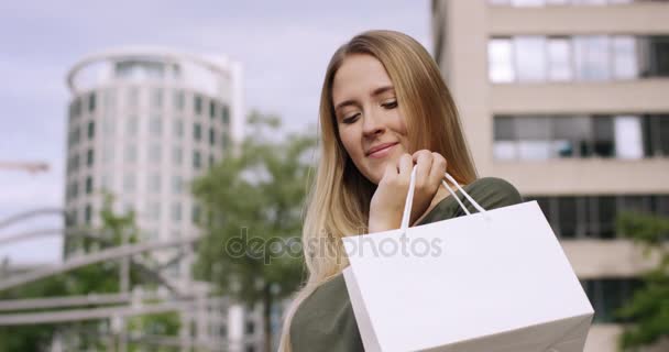 Ελκυστική ξανθιά γυναίκα ψάχνει στην τσάντα ψώνια της και είναι πραγματικά ευτυχισμένος — Αρχείο Βίντεο
