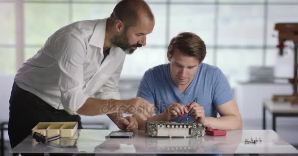 Estagiário de Electrican recebendo ajuda de seu treinador — Vídeo de Stock