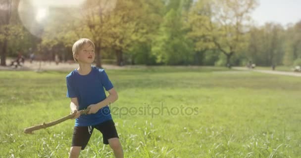 Menino está jogando beisebol com um pau de madeira lá fora — Vídeo de Stock