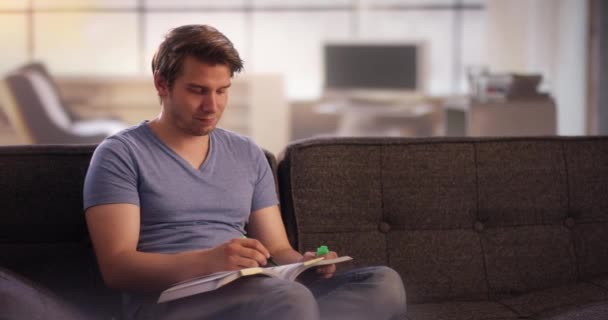 Ung mand markerer tekst i en bog – Stock-video
