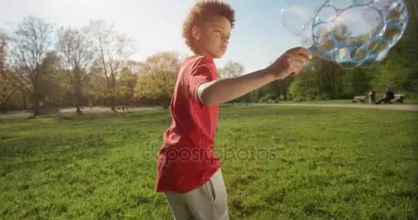 Liten pojke gör stora bubblor under körning — Stockvideo