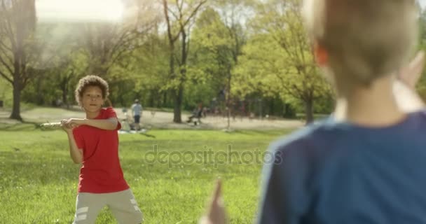 Twee jongetjes spelen honkbal met een houten stok buiten — Stockvideo