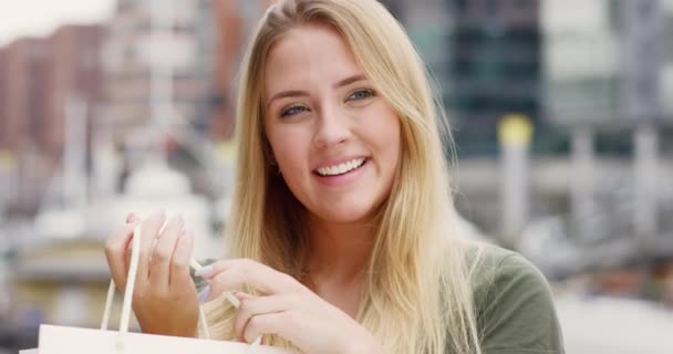 Vacker ung kvinna med shoppingväska ler glatt in kameran — Stockvideo