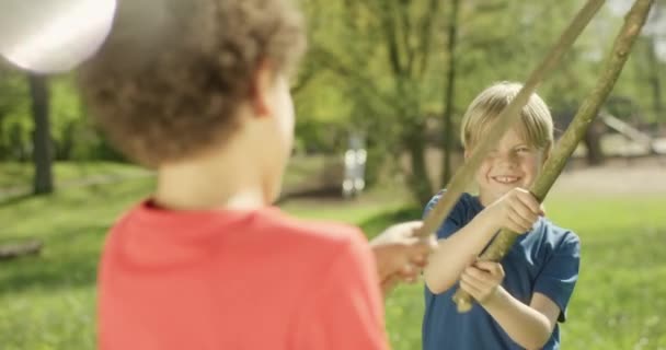 Netter Junge auf Spielplatz kämpft mit Stock — Stockvideo