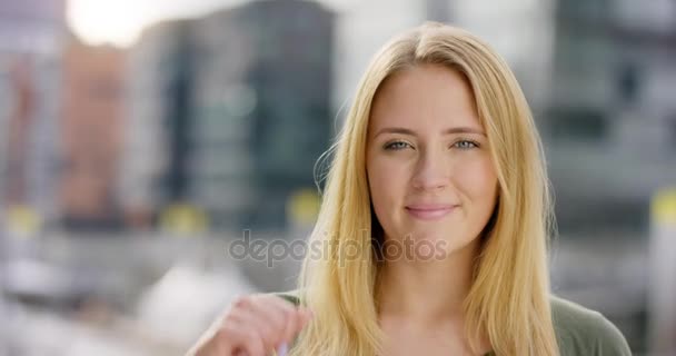 Hermosa chica sonriendo y señalando a la cámara — Vídeo de stock