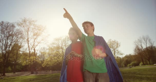 Söt ung pojke i grön tröja pekar mot himlen — Stockvideo