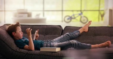 Çocuk değişiklikleri smartphone kanepede kitap karşı