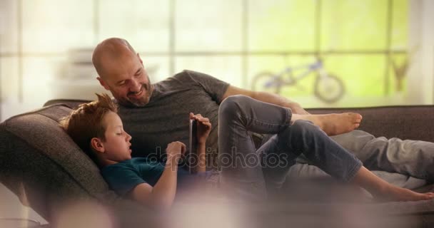 Far och son skojar runt på soffan — Stockvideo