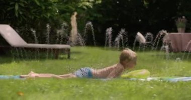 Genç kardeşler yeşil bir bahçe içinde bir kaydırağı yaz aylarında sürme sırasında eğlenmek