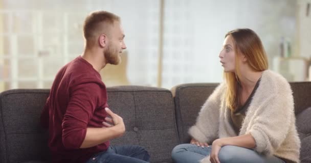 Casal jovem que tem diferenças em um sofá — Vídeo de Stock