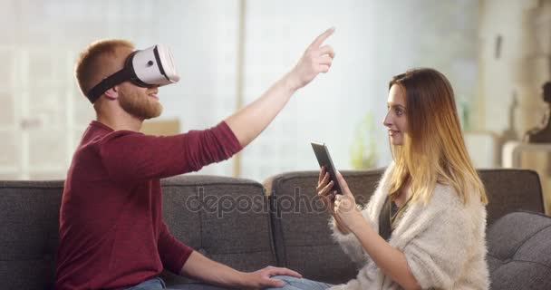 Pasangan muda manis di sofa bermain dengan VR dan bersenang-senang — Stok Video