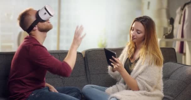 Jovem casal doce no sofá brincando com VR — Vídeo de Stock