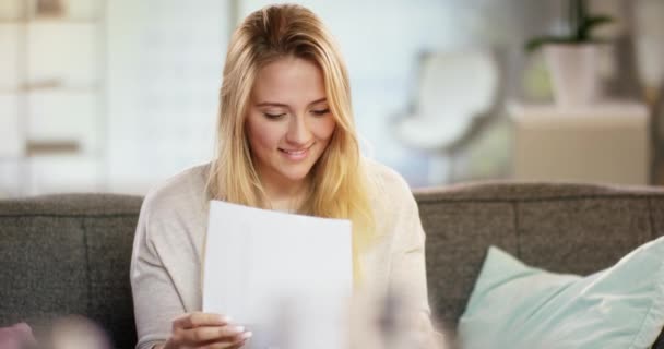 Счастливая молодая женщина читает письмо дома — стоковое видео