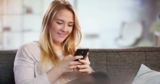 Молодая женщина пишет счастливые смски на свой телефон — стоковое видео