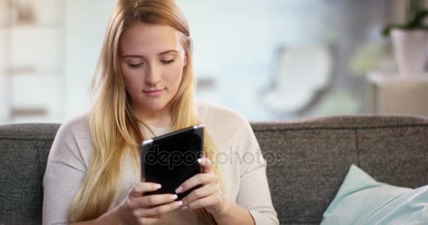 Mujer joven escribiendo algo en una tableta — Vídeo de stock