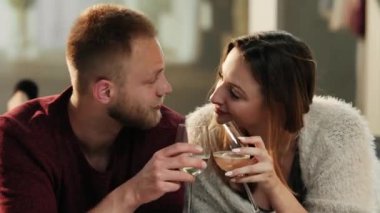 Genç çift yarık beyaz şarap bardakları kanepede yatarken