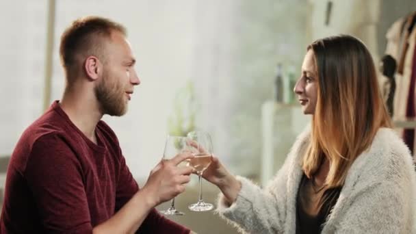 Young couple chink glasses and drinking white wine — Stock Video