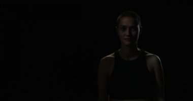 Kısa saçlı kadın karanlıktan adımlar ve silah haçlar