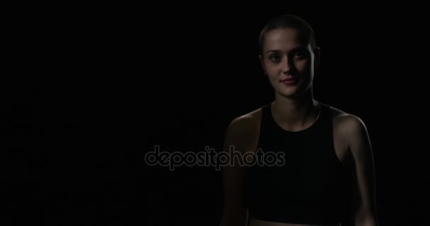 Young woman crossing arms in front of black background — Stock Video