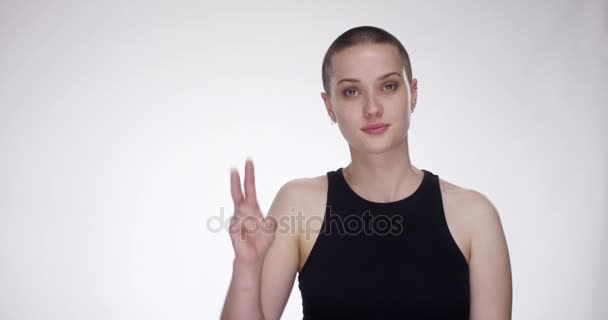 Junge Frau zeigt Siegeszeichen in die Kamera — Stockvideo