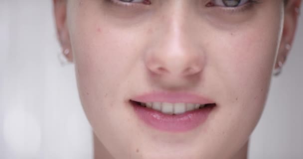 Детальный выстрел изо рта в глаза привлекательной молодой женщины — стоковое видео