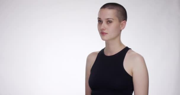 Young short haired woman turns and crosses her arms — Stock Video