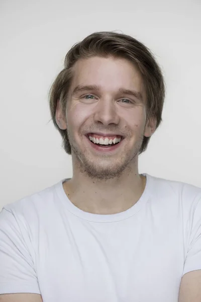 Genç çekici adam beyaz t-shirt kamera seyir için bir potrait ile