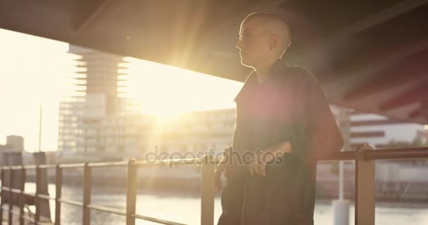 Женщина Короткими Волосами Отдыхает Мостом Городском Окружении Закате — стоковое видео