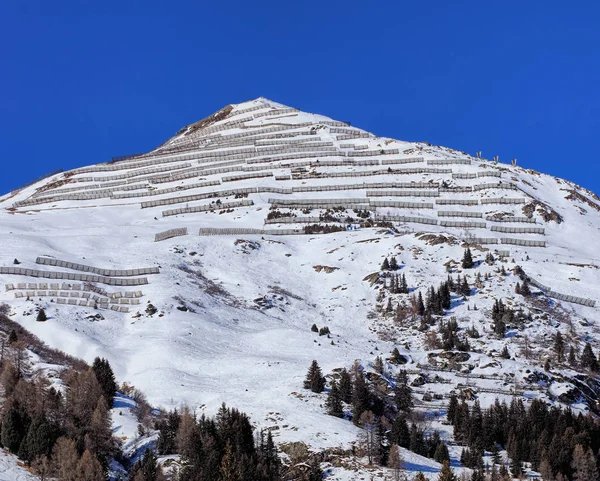 Cúpula de uma montanha nos Alpes Suíços com cercas de neve — Fotografia de Stock