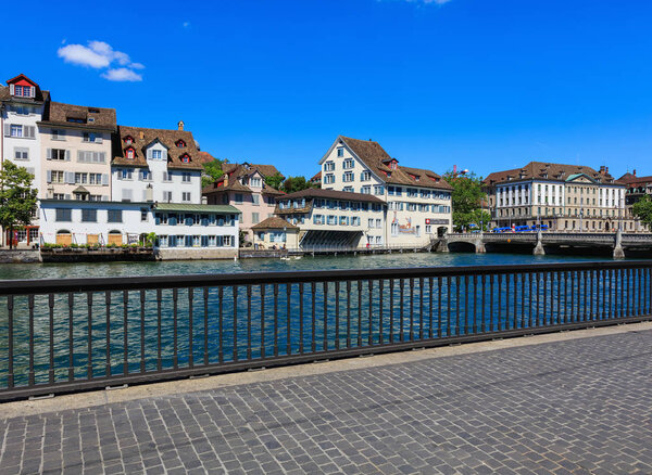 Zurich, Switzerland - 18 June, 2017: historical buildings along the Limmat river, people on the embankment of the river. Zurich is the largest city in Switzerland and the capital of the Swiss canton of Zurich.
