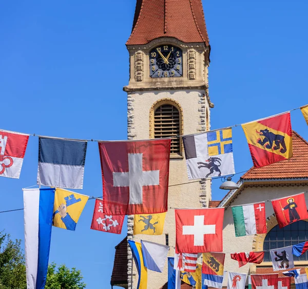 Calle en la ciudad de Wallisellen en Suiza decorada con banderas para el Día Nacional Suizo —  Fotos de Stock