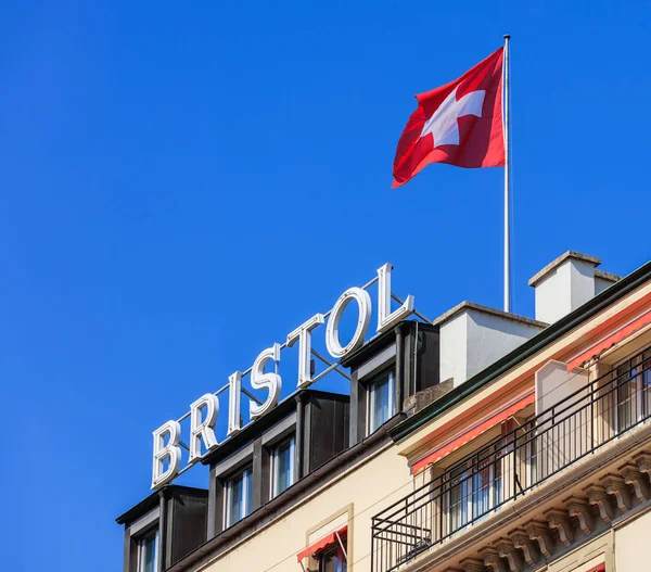 Sign and flag on the roof of the Hotel Bristol Geneva — Stock Photo, Image