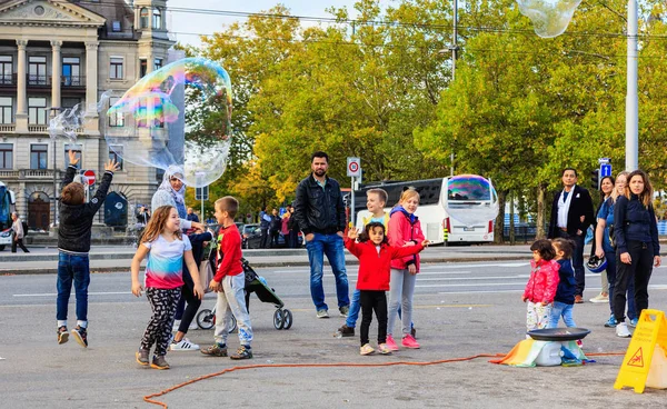 Sabun köpüğü yapma bir sokak sanatçı seyreden Zürih'te
