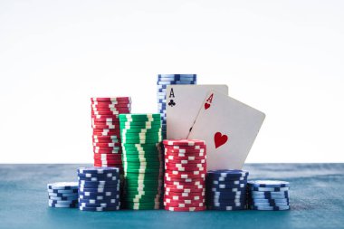 Beyaz zemin üzerinde iki as olan poker çipleri yığını izole