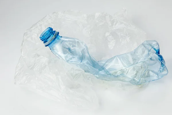 Plastflaska med cellofanpåse på lätt bakgrund. Ekologibegreppet. — Stockfoto