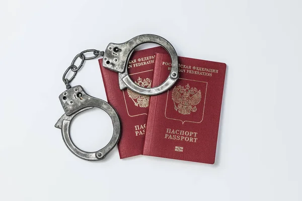 Два русских паспорта с наручниками на белом фоне — стоковое фото