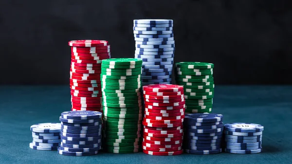 Stack of poker chips on a blue table on a black background — Stock Photo, Image