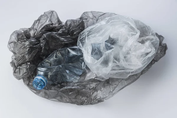 Plastic bags and crumpled bottles on a light background — Stock Photo, Image