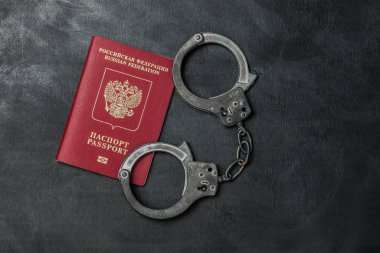 Russian passport with handcuffs on black background clipart