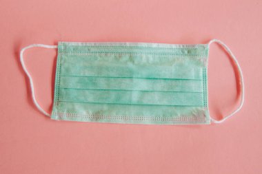 Açık pembe arka planda mavi tıbbi maske