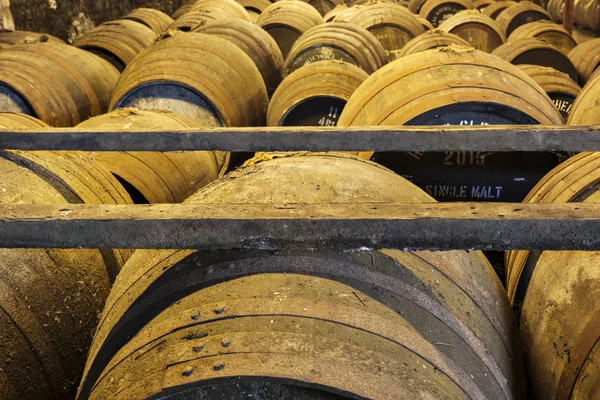 Velhos barris de madeira envelhecidos e cascos na adega do destilador de uísque — Fotografia de Stock