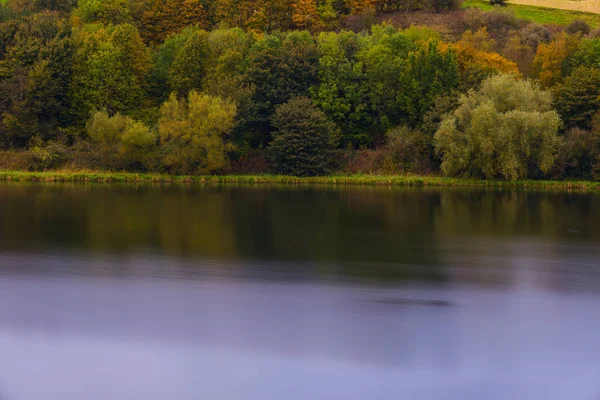 Bela floresta refletindo na costa calma do lago — Fotografia de Stock