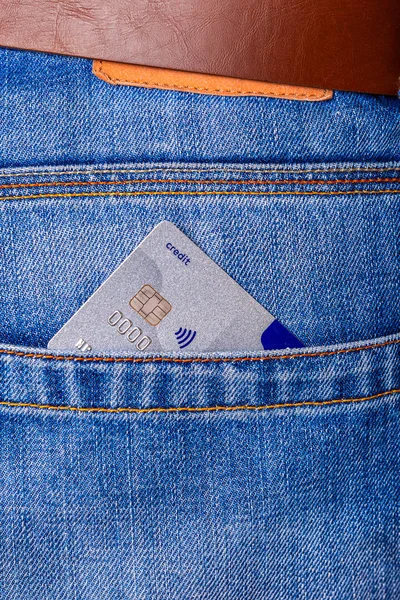 Érintésmentes hitelkártya közelsége, amely a kék farmerből kukucskál — Stock Fotó