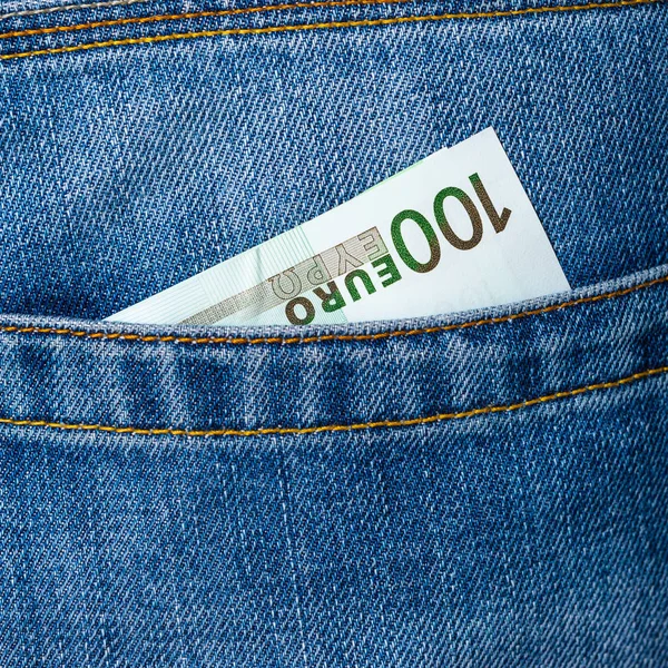 Closeup of one hundred Euro banknote peeking out of blue jeans b — Stock Photo, Image